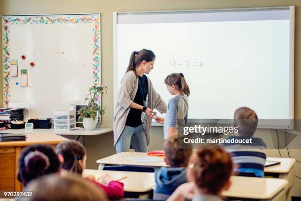 junges mädchen auf interaktiven whiteboard im klassenzimmer zu schreiben. - interaktives whiteboard stock-fotos und bilder