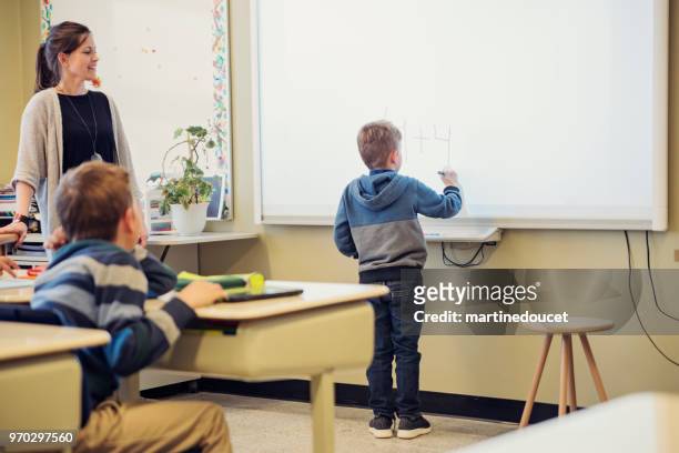 junge am interaktiven whiteboard im klassenzimmer zu schreiben. - interaktives whiteboard stock-fotos und bilder