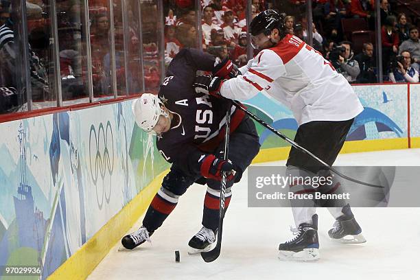 Dustin Brown of the United States fights for the puck Mark Streit of Switzerland against during the ice hockey men's quarter final game between USA...