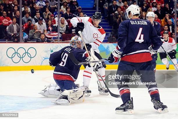 Ryan Miller of the United States makes a save against Roman Wick of Switzerland during the ice hockey men's quarter final game between USA and...