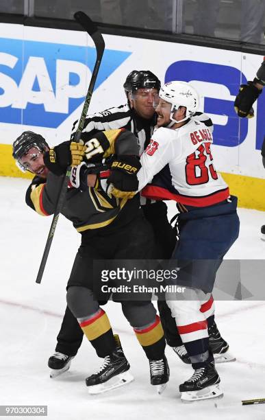 Linesman Jonny Murray tries to break up Reilly Smith of the Vegas Golden Knights and Jay Beagle of the Washington Capitals as they fight after Smith...