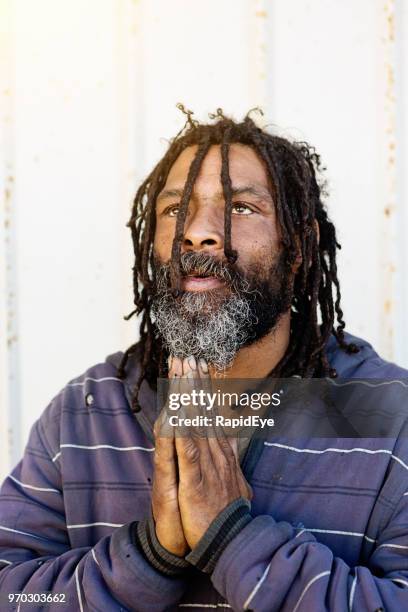 homeless man prays for a better future - rastafari hair stock pictures, royalty-free photos & images