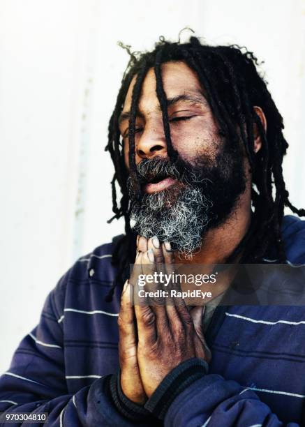 homeless man prays for a better future - rastafari hair stock pictures, royalty-free photos & images