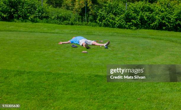 desperate golfer lying on the tee box with broken golf club driver - broken golf club stock pictures, royalty-free photos & images