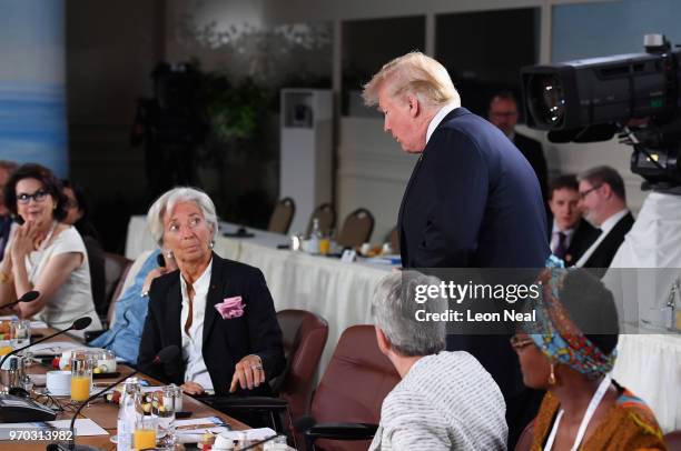 Christine Lagarde looks up at US President Donald Trump as he arrives late to the Gender Equality Advisory Council working breakfast on the second...