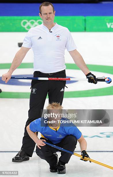 Sweden's Niklas Edin watches his stone with Briton Pete Smith during the Vancouver Winter Olympic men's curling tie-breaker match at the Vancouver...
