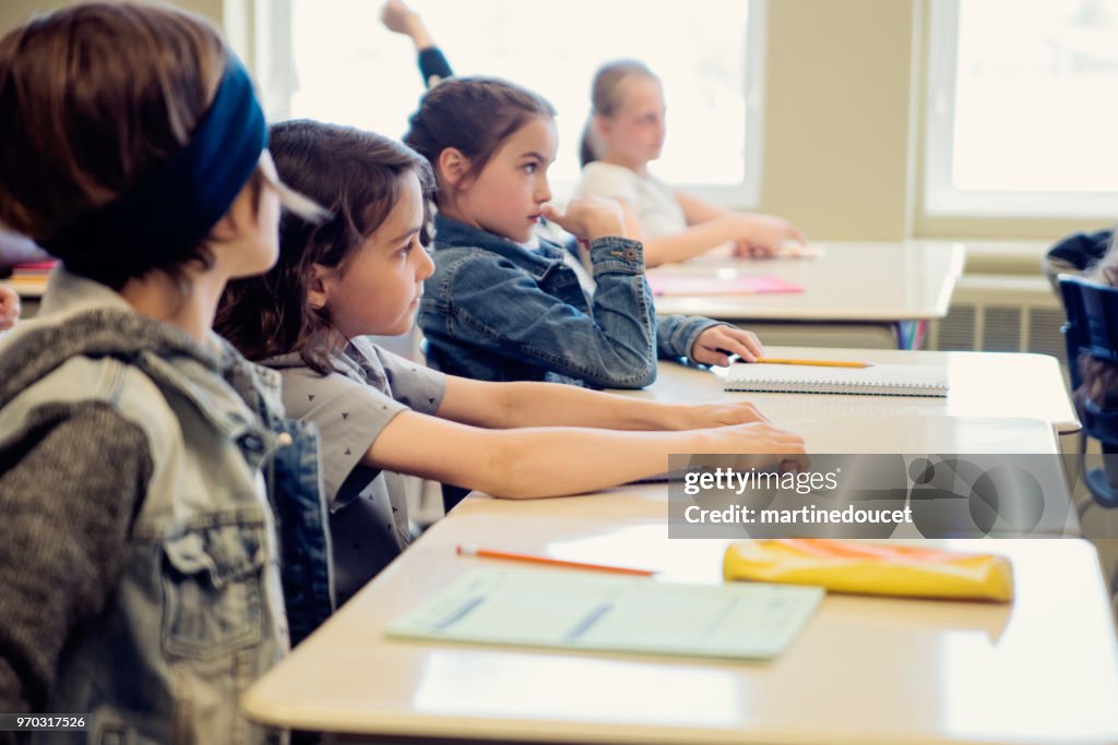 Folkskolan barn sitter och lyssnar i klassrummet.