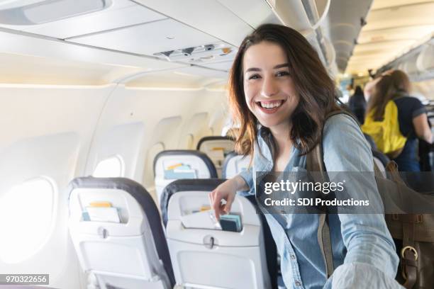 portrait of young woman boarding commercial airliner - aisle seat airline stock pictures, royalty-free photos & images