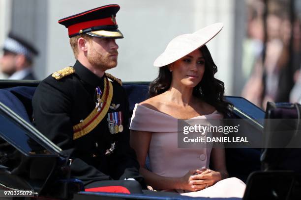 Britain's Prince Harry, Duke of Sussex and Britain's Meghan, Duchess of Sussex travel in a carriage to Horseguards parade ahead of the Queen's...