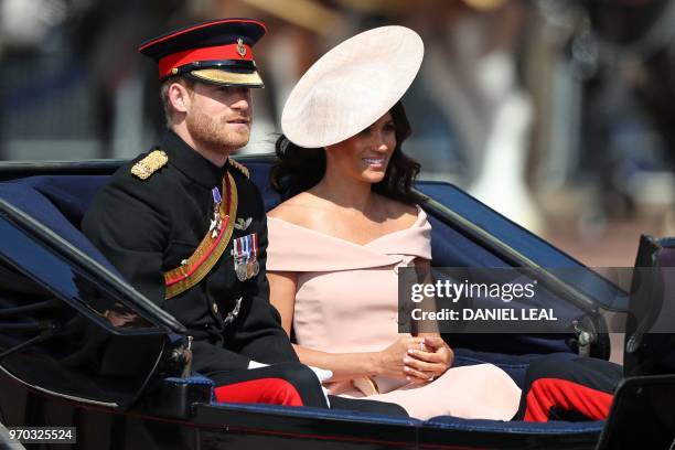 Britain's Prince Harry, Duke of Sussex and Britain's Meghan, Duchess of Sussex travel in a carriage to Horseguards parade ahead of the Queen's...