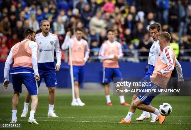 Russia's forward Fyodor Smolov and Russia's defender Andrey Semyonov vie for the ball during a training session at Moscow's VEB Arena stadium on June...