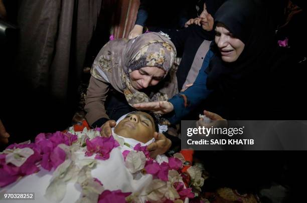 Graphic content / The mother and unidentified relatives of 15-year-old Haitham al-Jamal mourn over his body during his funeral in Rafah in the...