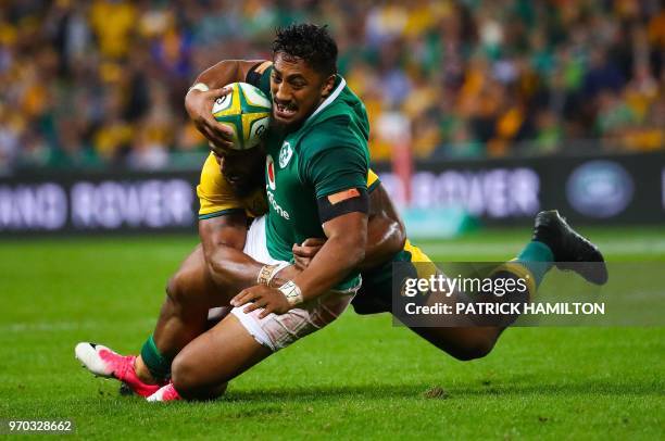 Ireland's Bundee Aki is tackled by Australia's Samu Kerevi during the first rugby Test between Australia and Ireland at Suncorp Stadium in Brisbane...