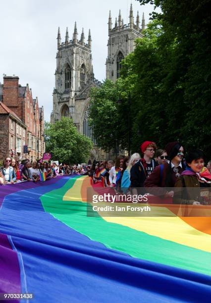 People hold a massive rainbow flag during the York Pride parade on June 9, 2018 in York, England. The parade made its way through the streets of the...