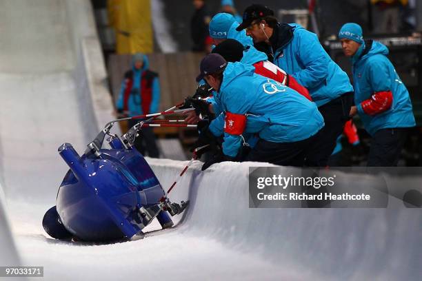 Gillian Cooke and Nicola Minichiello of Great Britain and Northern Ireland are helped from the track after Great Britain 1 crashed out during the...