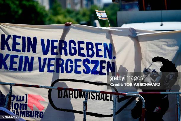 Protester holds a banner reading "No Forgiving, no forgetting" during an anti-Quds-day Demonstration on the occasion of the so-called "Al-Quds day"...