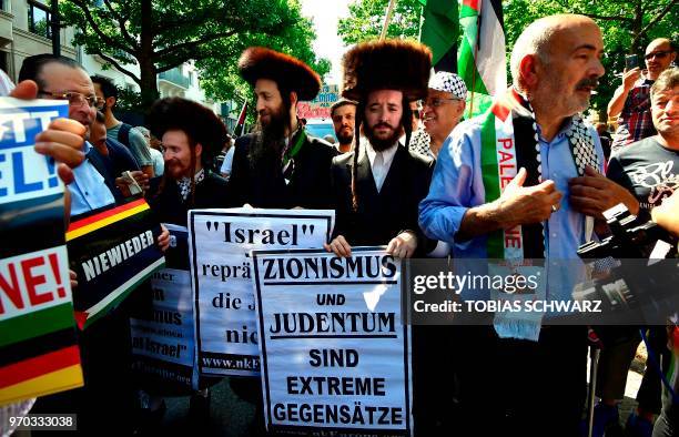 Protesters hold signs reading "Zionism and Judaism are extreme opposites" during a Quds-day Demonstration on the occasion of the so-called "Al-Quds...