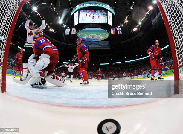 Evgeny Nabokov of Russia gives up a goal against Corey Perry of Canada in the first period during the ice hockey men's quarter final game between...