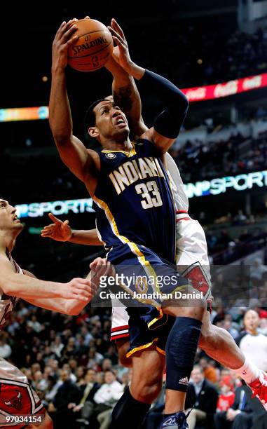 Danny Granger of the Indiana Pacers goes up for a shot between Kirk Hinrich and James Johnson of the Chicago Bulls at the United Center on February...