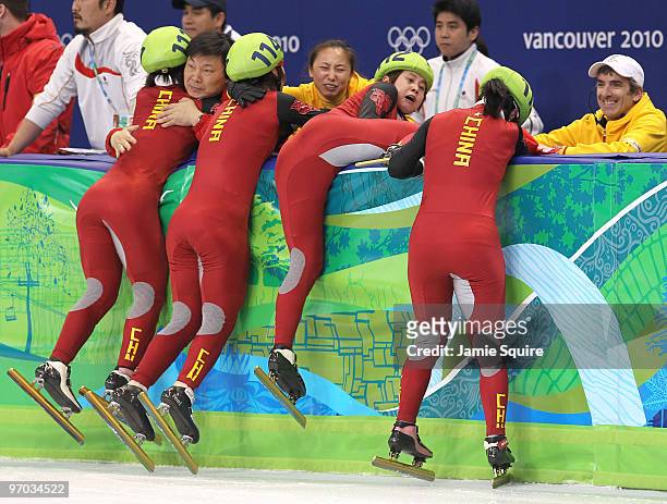 Wang Meng of China cuts the face of teammate Zhang Hui with the blade of her ice skate after Team China won the gold medal in the Short Track Speed...