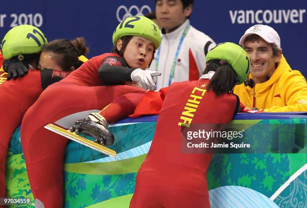 Wang Meng of China reacts after cutting the face of teammate Zhang Hui with the blade of her ice skate after Team China won the gold medal in the...