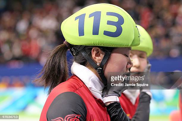 Zhang Hui of China reacts after teammate Wang Meng cut her face with the blade of her ice skate after Team China won the gold medal in the Short...
