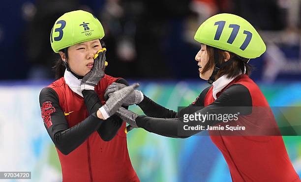 Sun Linlin of China reaches out to teammate Zhang Hui after teammate Wang Meng cut Zhang's face with the blade of her ice skate after Team China won...