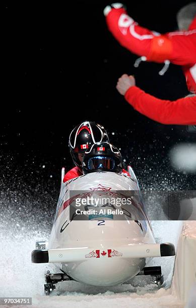 Kaillie Humphries and Heather Moyse of Canada in Canada 1 complete their fourth run to finish in first place and win the gold during the womens...