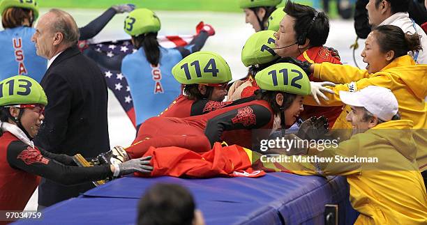 Wang Meng of China cuts the face of teammate Zhang Hui with the blade of her ice skate after Team China won the gold medal in the Short Track Speed...