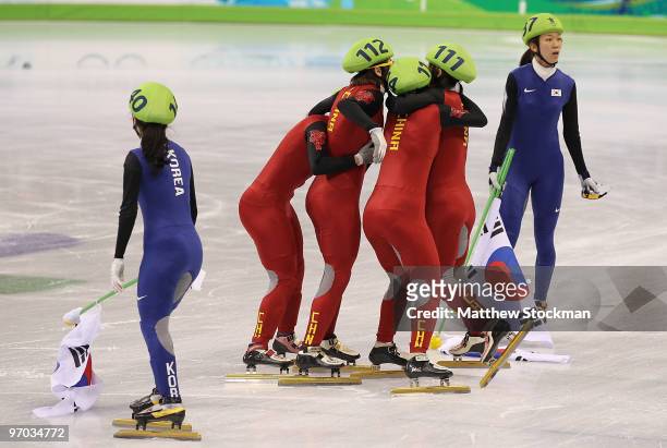 Lee Eun-Byul and Cho Ha-Ri of South Korea looks on as Zhang Hui, Wang Meng, Zhou Yang and Sun Linlin of China celebrate winning the gold medal, after...