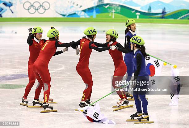 Lee Eun-Byul and Cho Ha-Ri of South Korea looks on as Sun Linlin, Zhou Yang, Wang Meng and Zhang Hui of China celebrate winning the gold medal, after...