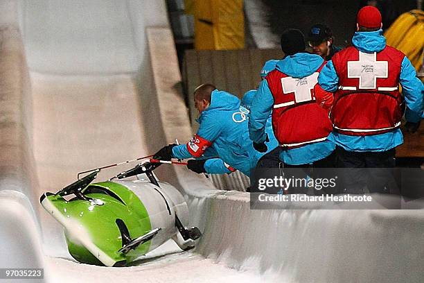 Cathleen Martini of Germany 2 is helped fom the track after they crashed out, team mate Romy Logsch of Germany fell from the back of the bobsleigh...