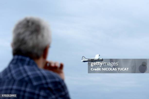 Spectator watches a De Havilland Beaver seaplane flying past during the International seaplane show in Biscarrosse, southwestern France, on June 9,...