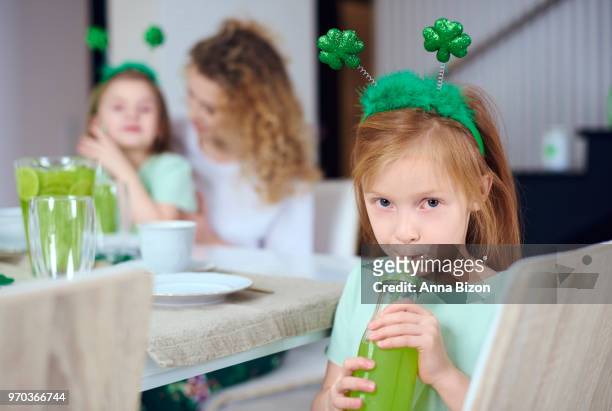 portrait of girl drinking green juice through a straw. debica, poland - haarreifen mit sternchen stock-fotos und bilder