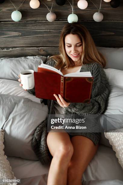 woman with a book and coffee relaxing in her bedroom. debica, poland - lazy poland fotografías e imágenes de stock