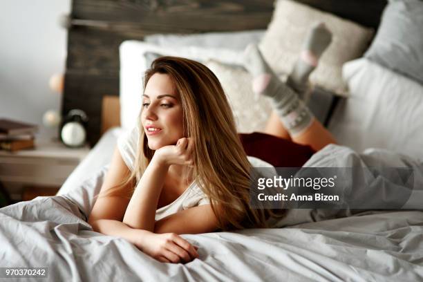 woman laying on stomach on bed. debica, poland - lazy poland stock pictures, royalty-free photos & images