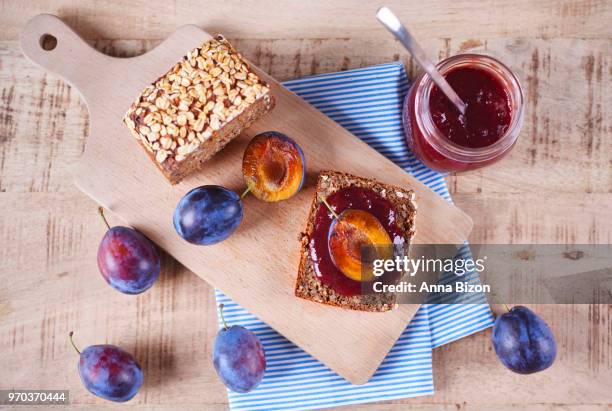 top view of health bread with fresh plum jam and plums on cutting board. debica, poland - marmalade sandwich stock pictures, royalty-free photos & images