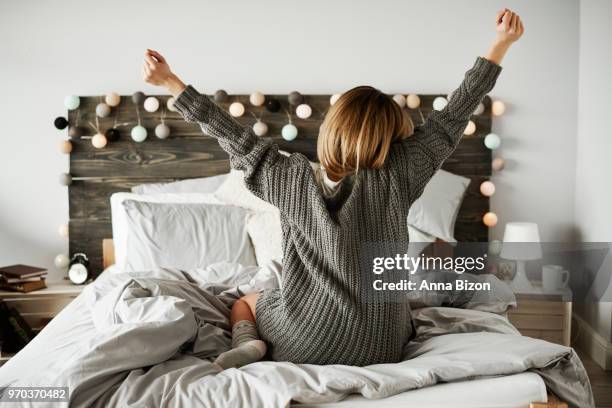 rear view of woman stretching in her bed. debica, poland - lazy poland stock pictures, royalty-free photos & images