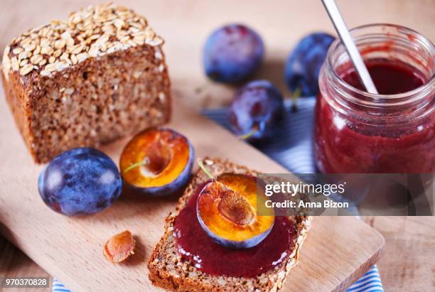 health bread with fresh plum jam and halved plum on wooden shopping board. debica, poland - marmalade sandwich stock pictures, royalty-free photos & images