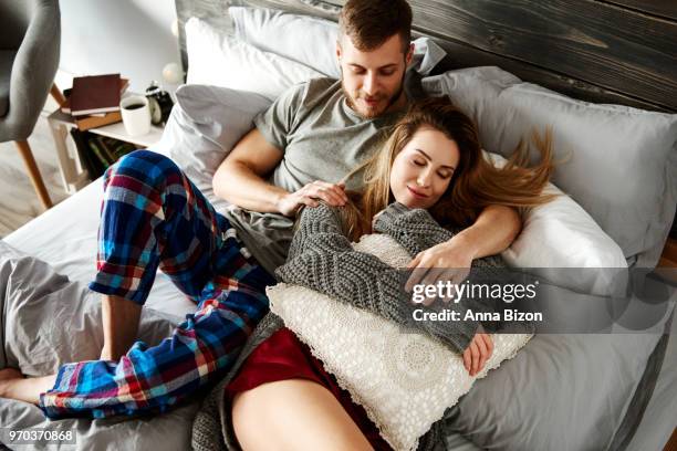 embraced couple relaxing in bed. debica, poland - lazy poland stock pictures, royalty-free photos & images