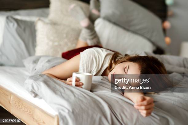 woman with coffee lying in bed. debica, poland - lazy poland fotografías e imágenes de stock