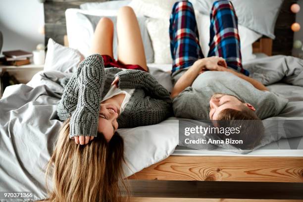 rear view of cheerful couple lying down on bed. debica, poland - lazy poland fotografías e imágenes de stock