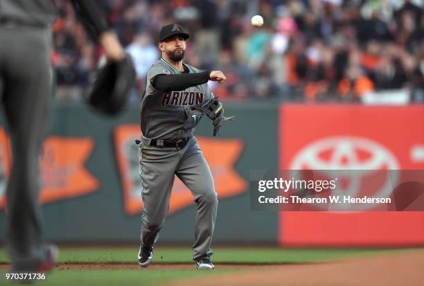 Deven Marrero of the Arizona Diamondbacks throws to first base throwing out Buster Posey of the San Francisco Giants in the bottom of the first...