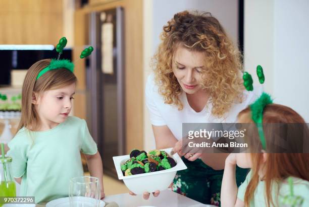 mother giving her children a cookie. debica, poland - deely bopper stock pictures, royalty-free photos & images