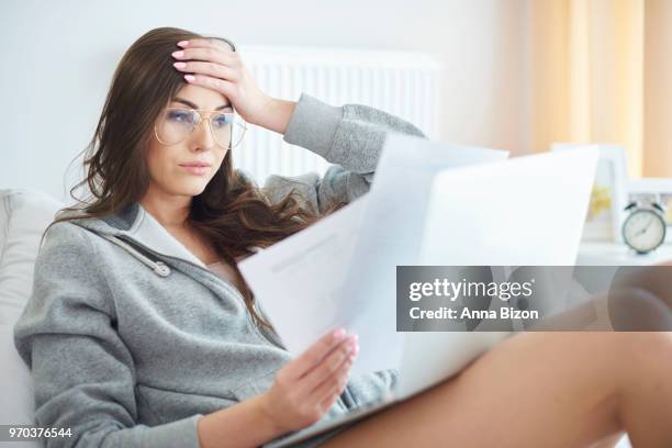 woman sitting, looking at papers, wearing glasses. debica, poland - anna bizon stock pictures, royalty-free photos & images