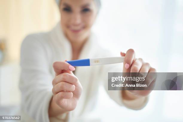 woman holding pregnancy test up to show camera. debica, poland - anna bizon stock pictures, royalty-free photos & images