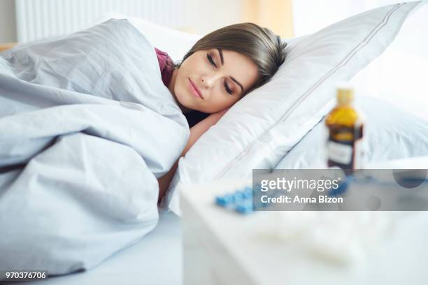 sick woman lying under the duvet. debica, poland - anna bizon stock pictures, royalty-free photos & images