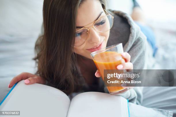 woman reading book and drinking juice. debica, poland - anna bizon foto e immagini stock