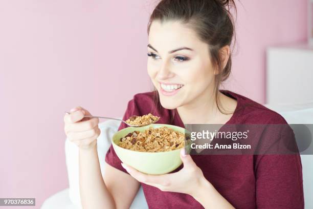 young woman having cereal with milk for breakfast. debica, poland - anna bizon foto e immagini stock