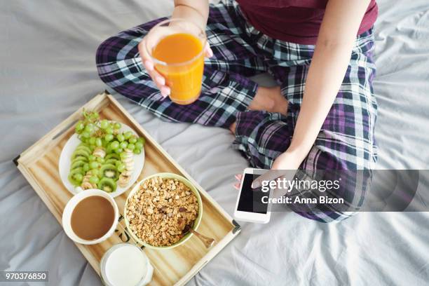 top view of woman sitting cross legged in bed, with tray of breakfast and coffee. debica, poland - anna bizon foto e immagini stock